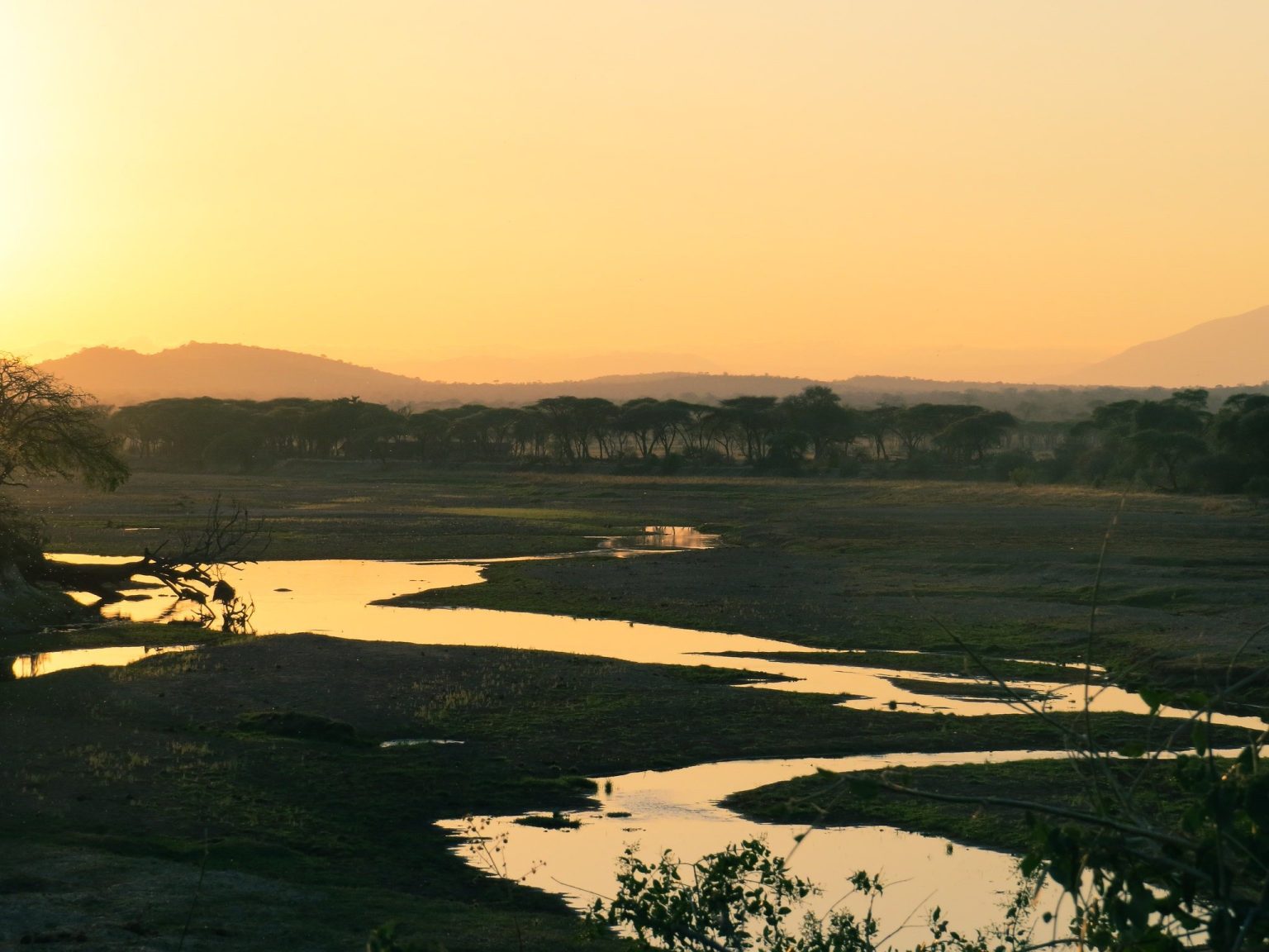Sunset over a winding river and open plains in Kenya