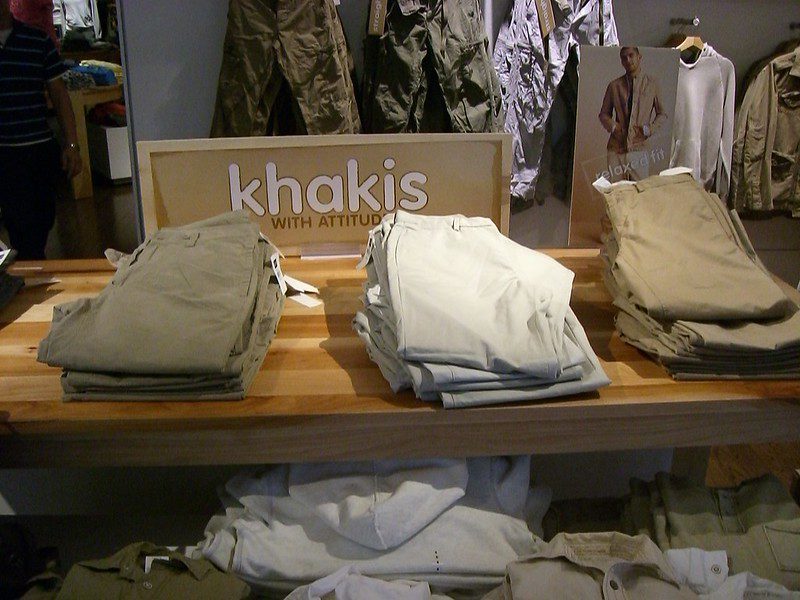 Stacks of khaki and stone coloured trousers on a shop table