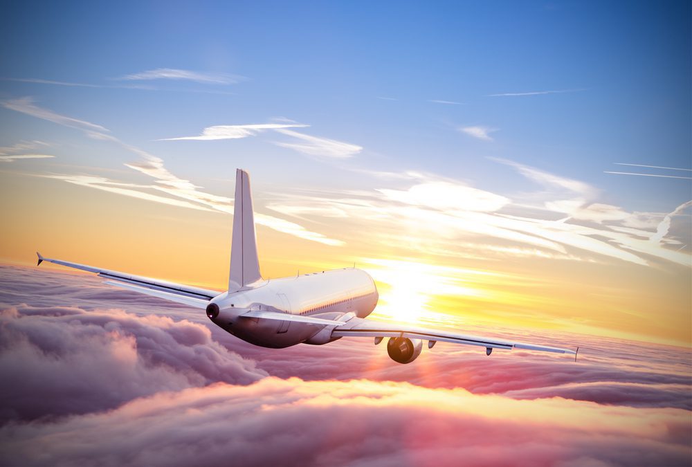 A long haul airliner flying above the clouds at sunset