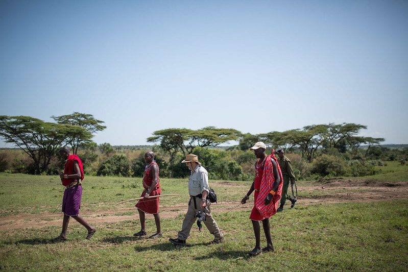 A walker in khaki clothes and a brimmed hat on a walking safari with Maasai guides and a ranger